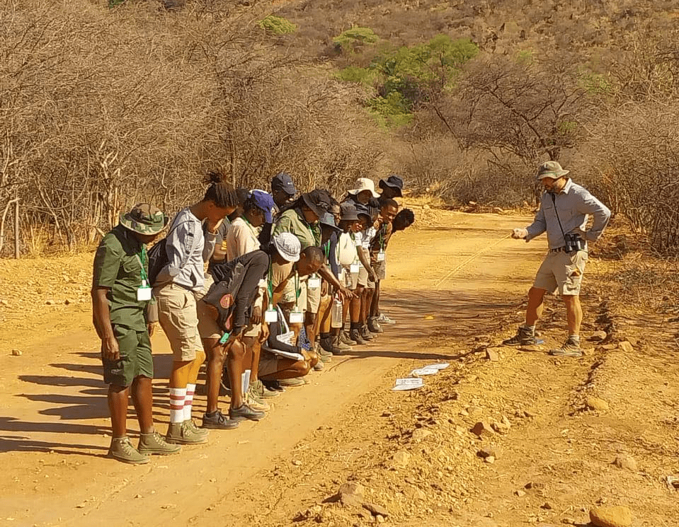 a group of people standing on a dirt road